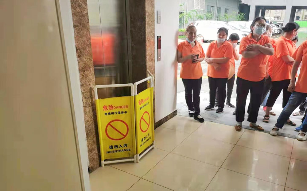 到达故障电梯所在处，在基站放置警示护栏，用三角钥匙打开层门观察轿厢所处位置