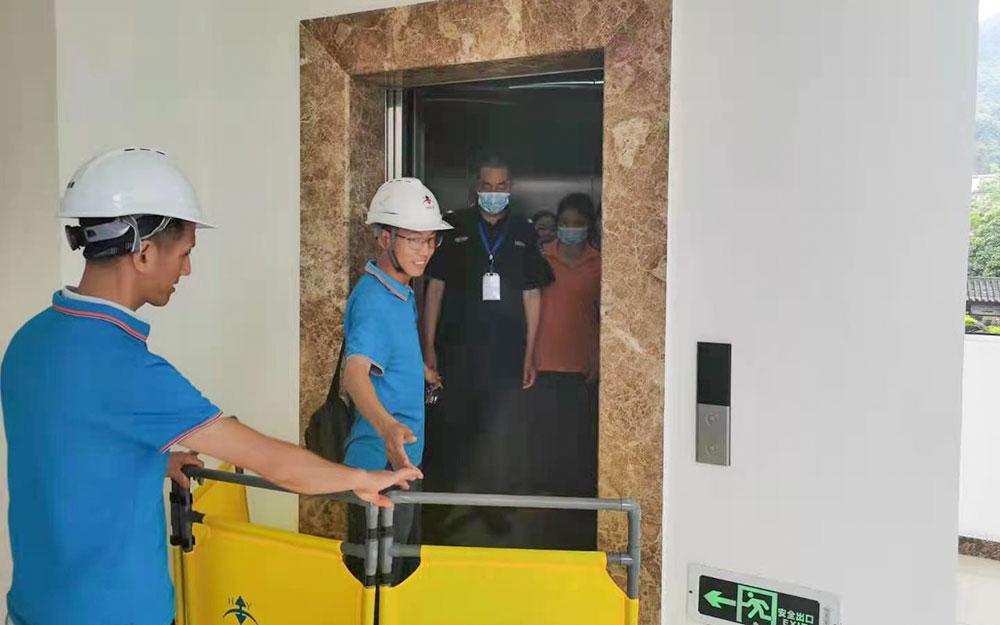 到达故障电梯所在处，在基站放置警示护栏，用三角钥匙打开层门观察轿厢所处位置